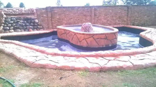 Outdoor water feature and pond with artificial rock landscaping